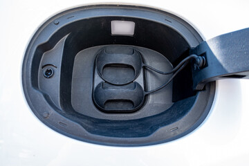 An electric vehicle (EV) charging high-voltage energy at an EV charging station replenishes its...