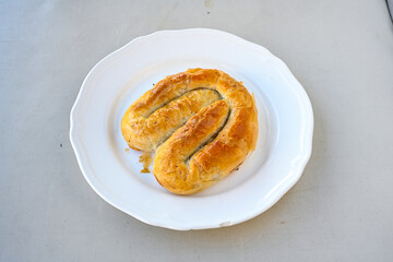 Turkish style meat stuffed filo dough borek served kol boregi.Cheese and minced pie are sliced on a marble background. Turkish name: Kol Boregi, kiymali, peynirli su boregi. Ci borek. Kafkas cig borek