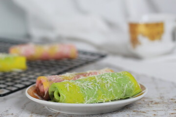 a close up of pancake rolls or Dadar Gulung with a rainbow pattern ready to be served. Food concept photo. Indonesian traditional food.