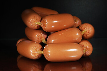 small sausages stacked in a hill on a dark background