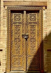 Ornate Wooden Door with Intricate Carvings in Sunlight