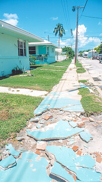 Damaged sidewalk and suburban houses after hurricane andrew in florida
