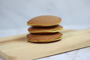 Delicious Stack of Three Fluffy Japanese Pancakes on Wooden Board