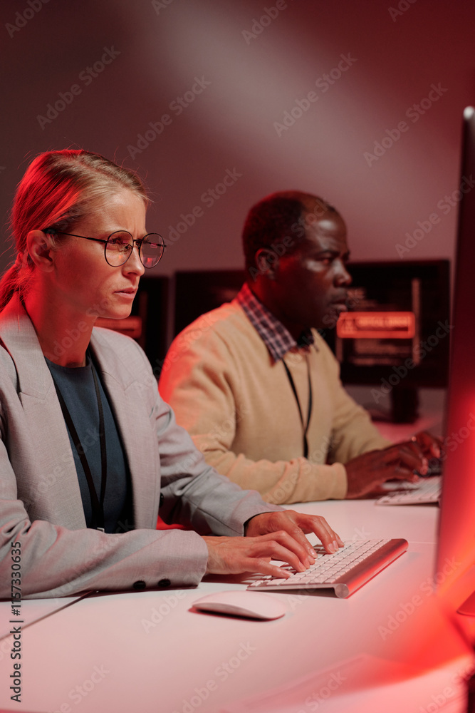 Aufkleber Young IT support manager in formalwear looking at computer screen while solving technical problem against male coworker