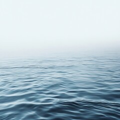 Naklejka premium Calm ocean water with a misty horizon.