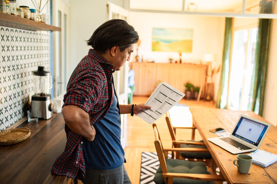 Man reviewing documents in home office kitchen setup
