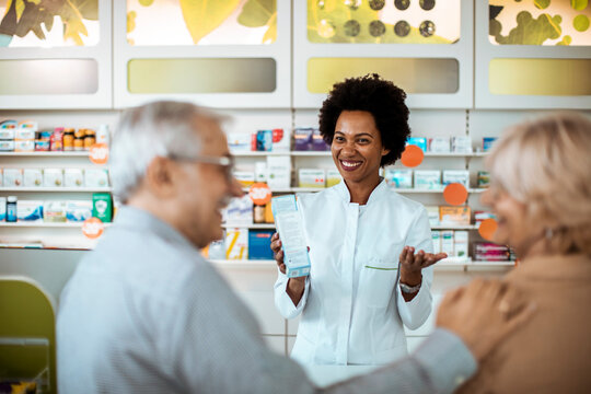 Pharmacist assisting senior couple with medication choice in pharmacy