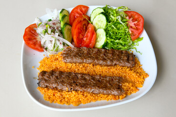 Grilled Turkish Adana, Urfa  Kebab with grilled vegetables, onion and rice on plate. Adana durum, Urfa durum .