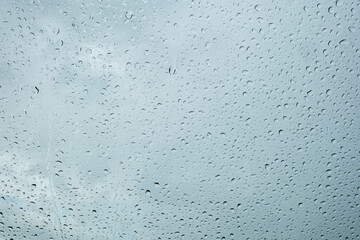 Obraz premium Raindrops accumulate on a windowpane during an overcast day in an urban setting