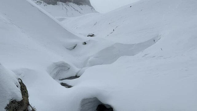 winter mountains landscape by a cloudy day; aiguilles d'arves in winter with a river at first plan
