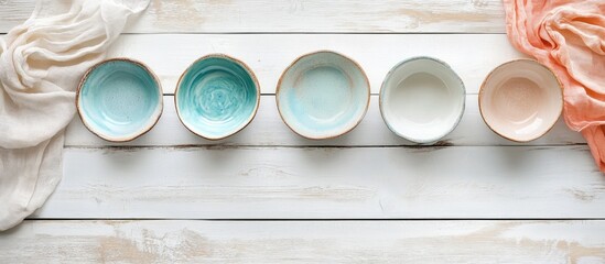 Handcrafted ceramic bowls and colorful textiles arranged on a rustic wooden surface with room for textual content