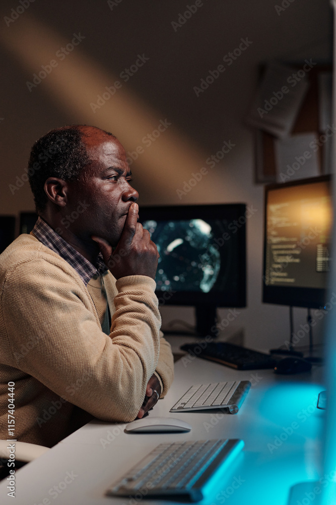 Aufkleber pensive african american male programmer keeping fingers by mouth and looking at computer screen whi