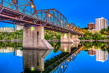 Fototapeta premium A bridge spans a river with a city in the background