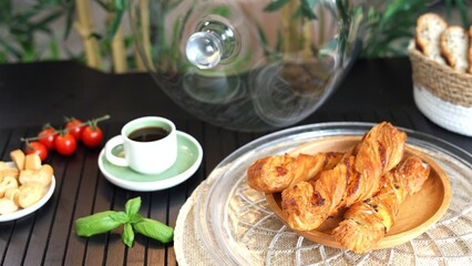 Minimalist tableware setup with coffee, breadsticks, cherry tomatoes on sleek ceramic, capturing simplicity of cozy meals and contemporary design near crystal-clear cake dome.