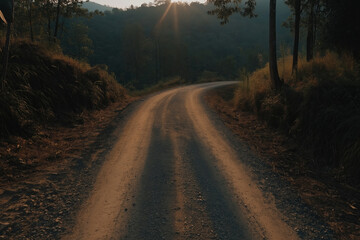 Obraz premium Serene dirt road winding through the hills during golden hour in nature