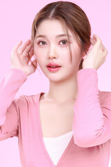 Fototapeta premium Portrait of a Smiling Asian Woman fresh skin in Stylish Pink Attire Against a Soft Background.