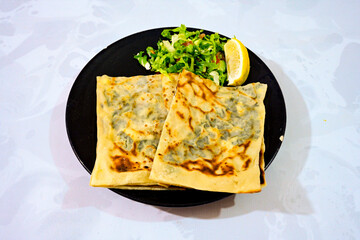 Turkish style meat stuffed filo dough borek served kol boregi.Cheese and minced pie are sliced on a marble background. Turkish name: Kol Boregi, kiymali, peynirli su boregi. Ci borek. Kafkas cig borek