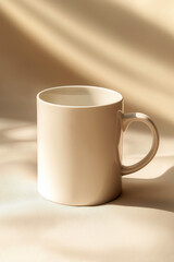 Fototapeta premium Minimalist shot of a clean white coffee mug on a smooth beige background, with subtle soft shadows.