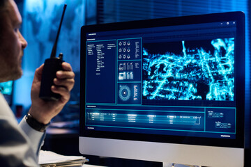 Computer monitor with army location on screen standing in front of male officer with walkie-talkie...