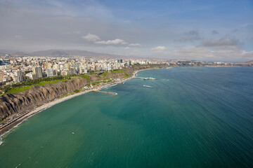 Fototapeta premium An aerial view of Lima’s Costa Verde reveals the perfect blend of urban life and natural beauty.With cliffs that kiss the Pacific and waves that call to surfers, this coastline is pure magic.