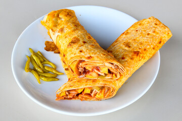 Lavash doner kebab ( soslu kasarli zurna doner durum )  or shawarma sliced in plate isolated.  Tavuk Et Doner Durum. Hatay Iskenderun usulu bazuka tavuk doner durum.