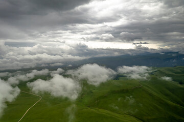 Fototapeta premium Mountains in the clouds, low clouds in a mountain valley. Landscape and nature of the North Caucasus