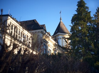 Elegant Historic Mansion with Tower and Trees in Golden Hour Light