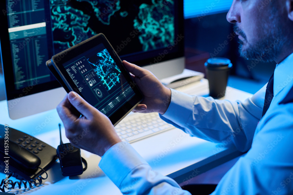 Poster hands of mature man in military uniform sitting by desk and looking at graphic data on tablet screen