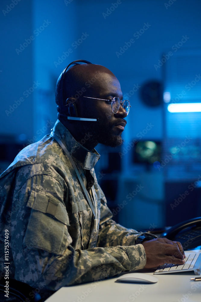Aufkleber african american man in camouflage uniform and headset speaking in microphone, typing on computer ke