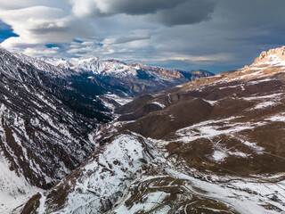 Beautiful aerial view of snowy peaks in a picturesque gorge. Landscape and nature of the North Caucasus