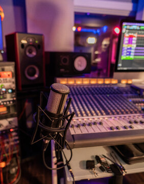 professional microphone with a sound mixer and studio monitors in a recording studio 