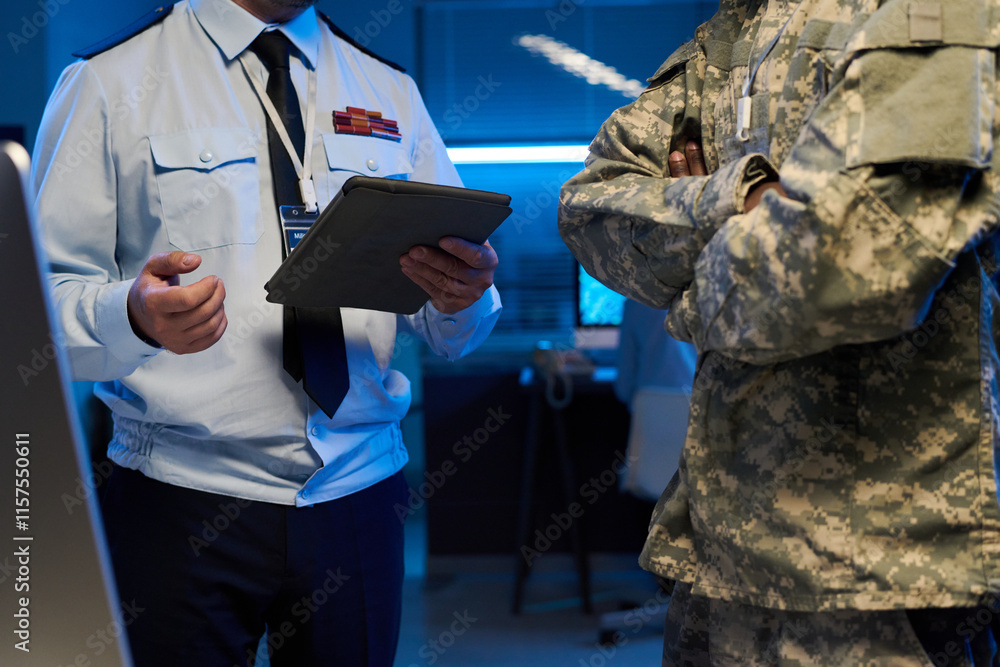Poster Two unrecognizable male officers in uniform standing in front of camera during discussion of military information