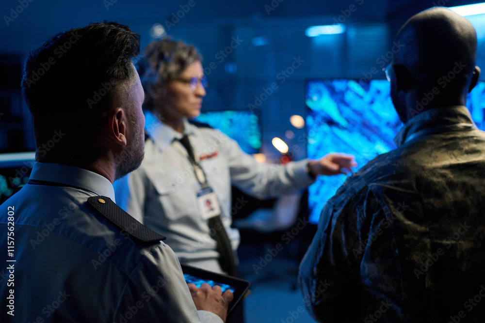 Aufkleber rear view of two intercultural male officers standing in front of their female colleague making pres