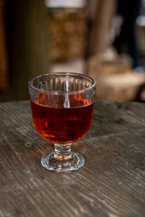 glass of red drink wine on wooden table