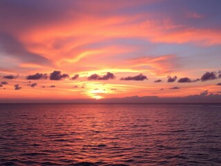 Breathtaking Sunset Over Calm Ocean Waters with Vibrant Pink and Orange Sky, Clouds Reflecting Colors, Peaceful Nature Scene at Dusk