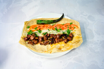 Famous Urfa meat liver, ciger wrapped by lavash with roasted chili pepper, onion and sauce in Sanliurfa, Turkey. Kuzu et ciger sis. Izgara dana bonfile, cop sis, kuzu pirzola. Karisik kebap, beyti keb
