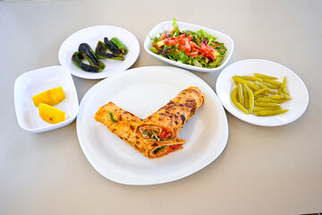 Lavash doner kebab ( soslu kasarli zurna doner durum )  or shawarma sliced in plate isolated.  Tavuk Et Doner Durum. Hatay Iskenderun usulu bazuka tavuk doner durum.