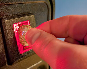 hand Putting a coin into an arcade game slot