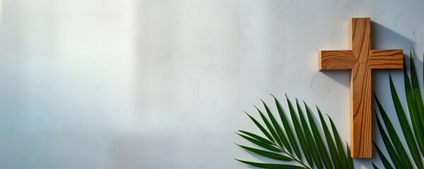 Wooden cross on light gray background. Palm Sunday elements. Christian religious symbol. Concept photo. Suitable for religious publications. Easter Lent related image. Represents faith, sacrifice.