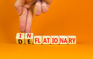 Deflationary or inflationary symbol. Concept words Deflationary Inflationary on wooden blocks. Beautiful orange background. Businessman hand. Business deflationary inflationary concept. Copy space