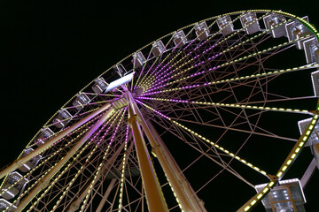 Glowing ferris wheel in the night, amusement park attraction