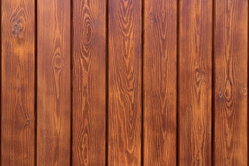 Wooden wall with warm brown planks featuring natural grain and knots. Rustic texture for design backgrounds