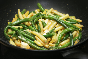 Fried yellow and green beans with olive oil and feta cheese. Shiny vegetables with rich flavor. Healthy and affordable dish idea. Perfect for a nutritious and delicious meal. Food lover paradise.