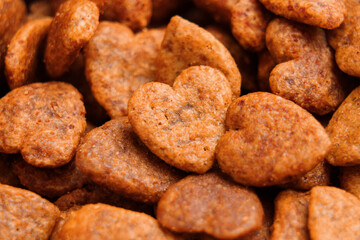 Heart-shaped cat snacks for balanced nutrition with wholesome grain-free ingredients. Golden brown color and crispy texture. Pet health care concept