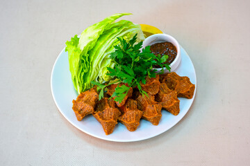 Cig kofte (raw meatball) with lettuce, tomato, pickle and lemon, hot Chee kofta. Turkish local raw food concept.Table scene of assorted take out or delivery foods. Doritoslu duble cig kofte durum.