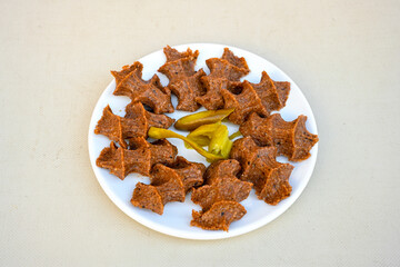 Cig kofte (raw meatball) with lettuce, tomato, pickle and lemon, hot Chee kofta. Turkish local raw food concept.Table scene of assorted take out or delivery foods. Doritoslu duble cig kofte durum.