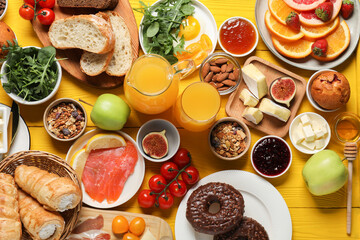 Different tasty food served for brunch on yellow wooden table, flat lay