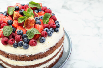 Delicious chocolate sponge cake with berries on white table, closeup