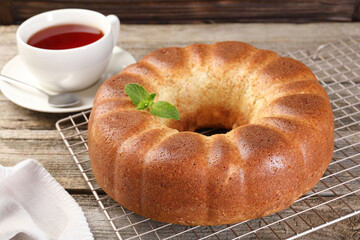 Freshly baked sponge cake and tea on wooden table, closeup