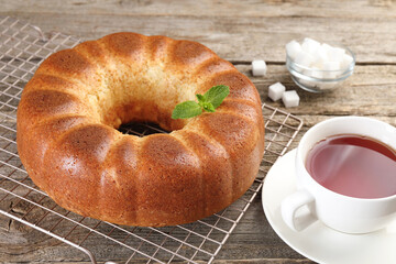 Freshly baked sponge cake, sugar cubes and tea on wooden table, closeup